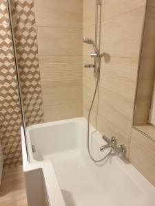a bathroom with a bath tub with a shower at Mártika Apartment in Siófok
