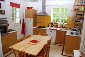 een keuken met een houten tafel en een keuken met gele tegels bij Les impressionnistes Maison de famille in Saint-Aubin-sur-Scie