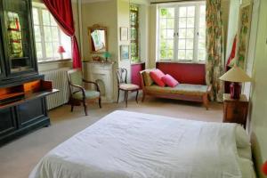 een slaapkamer met een bed, een bank en ramen bij Les impressionnistes Maison de famille in Saint-Aubin-sur-Scie
