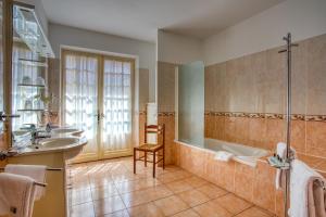 y baño con 2 lavabos, bañera y ducha. en Noreli B&B, en Sarlat-la-Canéda