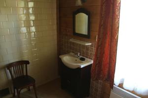 a bathroom with a sink and a mirror and a chair at Folwark Stare Masiewo TRYBA in Narewka