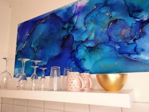 a shelf with glass bottles and a painting at Harmony Apartment in Gelsenkirchen