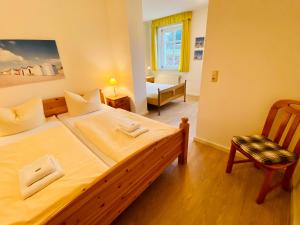 ヘリングスドルフにあるVilla Caprivi - Ferienwohnung E2のベッドルーム1室(大型ベッド1台、椅子付)