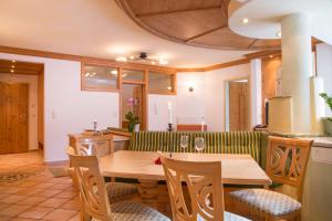 kuchnia z drewnianym stołem i zieloną kanapą w obiekcie Fliana Arlberg Studios & Apartments w mieście Sankt Anton am Arlberg +18 zdjęć
