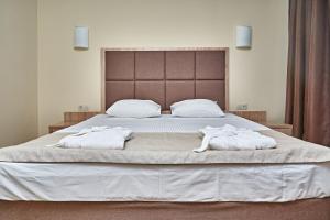 1 dormitorio con 1 cama grande y toallas. en Park Hotel Akter Ruza, en Staraya Ruza