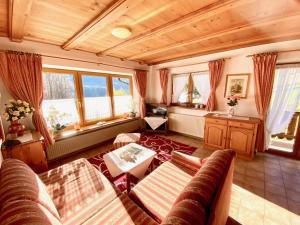 a living room with a couch and some windows at Berghof Punzenlehen - nahe Königssee in Bischofswiesen