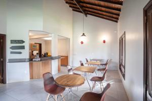 a dining room with two tables and chairs and a counter at Parador Casa da Praia in Torres