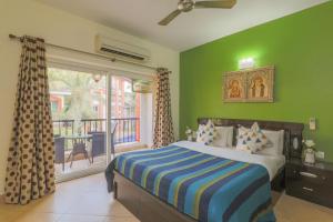 a bedroom with green walls and a bed and a window at Heritage Exotica Villa - 4BHK, Baga in Baga