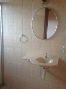 a bathroom with a sink and a mirror at Pousada Cachyto de Cielo in Campos do Jordão