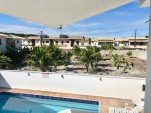 a view from the balcony of a house with a swimming pool at Beverly Hills Flat in Porto Seguro