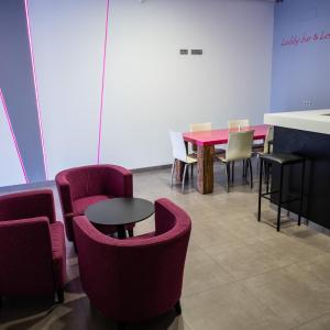 Alix Boutique في أرتيكسو: غرفة بها كراسي حمراء وطاولة وكراسي