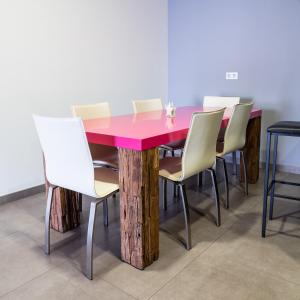 une table en bois entourée de chaises blanches dans l'établissement Alix Boutique, à Arteixo