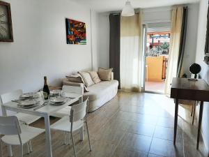 sala de estar con mesa y sofá blanco en Rosie House 2, en Parque Holandes