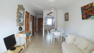 Una sala de estar con un sofá blanco y una mesa. en Rosie House 2, en Parque Holandes