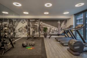 un gimnasio con máquinas de ejercicio y un mural de un puente en INNSiDE by Meliá Newcastle en Newcastle