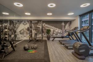 a gym with exercise equipment and a mural of a bridge at INNSiDE by Meli&aacute; Newcastle in Newcastle upon Tyne