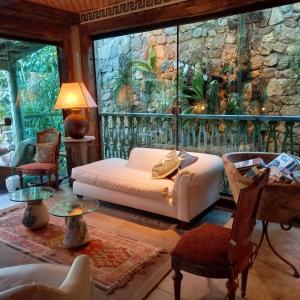 a living room with a couch and a stone wall at Pousada Pilar in Arraial do Cabo