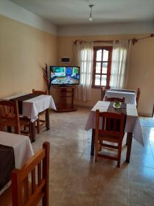 een woonkamer met tafels en een flatscreen-tv bij HOSTAL LA PLAZA IRUYA in Iruya