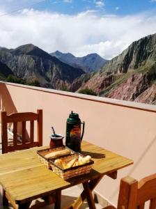 a table with a basket of bread on top of a mountain at HOSTAL LA PLAZA IRUYA in Iruya