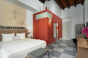 a bedroom with a white bed and a red wall at Palacio Provincial San Juan, Adults only, Curio Collection by Hilton in San Juan +61 photos