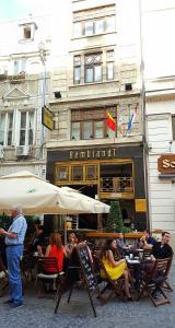 people sitting outside of a restaurant with umbrellas at Rembrandt Hotel in Bucharest