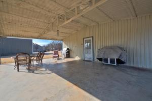 a garage with chairs and a table and a grill at Lake Time Bar & Chill in Kingston