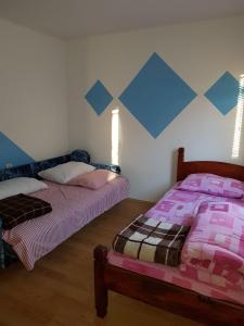 2 camas en una habitación de color azul y rosa en Zlatiborska jutra, en Zlatibor