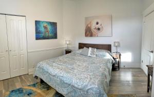 a bedroom with a bed and two paintings on the wall at The Elm Tree Cottage in the Sugarhouse District in Salt Lake City