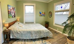 a bedroom with a bed and two windows at The Elm Tree Cottage in the Sugarhouse District in Salt Lake City