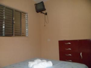 sypialnia z łóżkiem i telewizorem na ścianie w obiekcie Candairó Hotel Pousada w mieście Cananéia