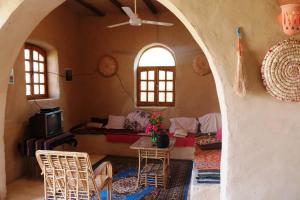 a living room with a table and chairs in a room at Desert Rose Guesthouse in Luxor