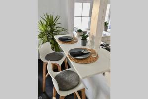 - une table à manger avec des chaises et une table blanche dans l'établissement Ferienwohnung Brötzingen Westliche KF - DG, à Pforzheim