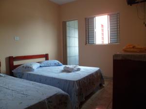 1 dormitorio con 2 camas y ventana en Candairó Hotel Pousada, en Cananéia