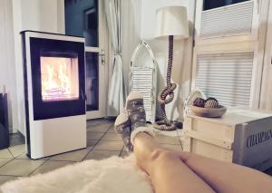 a person laying on a rug in front of a fireplace at Strandhaus Rügen - Sauna, Kamin, Whirlpool in Baabe