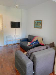 een woonkamer met een bank en 2 stoelen bij Estúdio/Apartamento praia de São Vicente in São Vicente