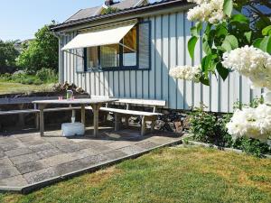 a picnic table and a bench in front of a house at 4 person holiday home in H n in Hönö