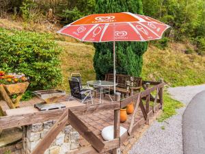 eine Terrasse mit einem Sonnenschirm, einem Tisch und Stühlen in der Unterkunft Apartment with forest in Goldisthal Thuringia in Goldisthal