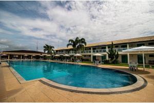 a large swimming pool in front of a hotel at Hotel Fazenda Alto Alegre in Jaguaripe
