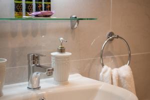 a bathroom sink with a soap dispenser on it at M City Apartments 100m from the beach in Chania