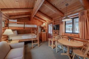 a bedroom and living room in a log cabin at Cowboy Village Resort in Jackson