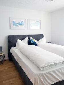 2 camas en un dormitorio con sábanas y almohadas blancas en The Seefeld Retreat - Central Family Friendly Chalet - Mountain Views, en Seefeld in Tirol
