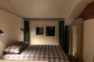 een slaapkamer met een bed met 2 kussens erop bij Karibu de Stallen (met Sauna en Stoom douche) in Daarle