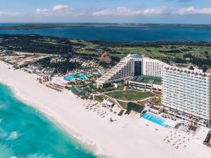 a beach with a large building and a large body of water at Coral Level at Iberostar Selection Cancun in Cancún