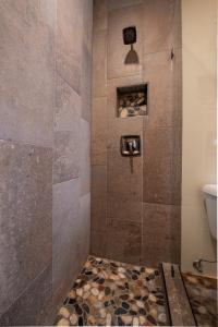 a bathroom with a shower with a stone floor at Cowboy Village Resort in Jackson