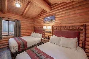 a hotel room with two beds and a tv at Cowboy Village Resort in Jackson