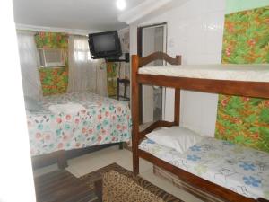 a room with two bunk beds and a tv at A meson Suites in Salvador