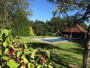 a yard with a swimming pool and a house at Street Farmhouse in Godshill
