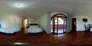 a bedroom with two beds and an open door at RECANTO CANTAGALO Hotel in Cantagalo