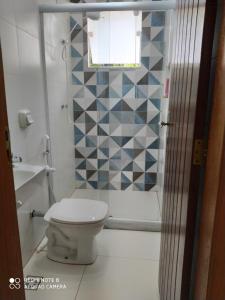 a bathroom with a toilet and a shower at Espaço Mangue House in Barra de Guaratiba