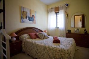 Schlafzimmer mit einem Bett und einem Spiegel in der Unterkunft Casa Cristina in Callosa d'en Sarrià